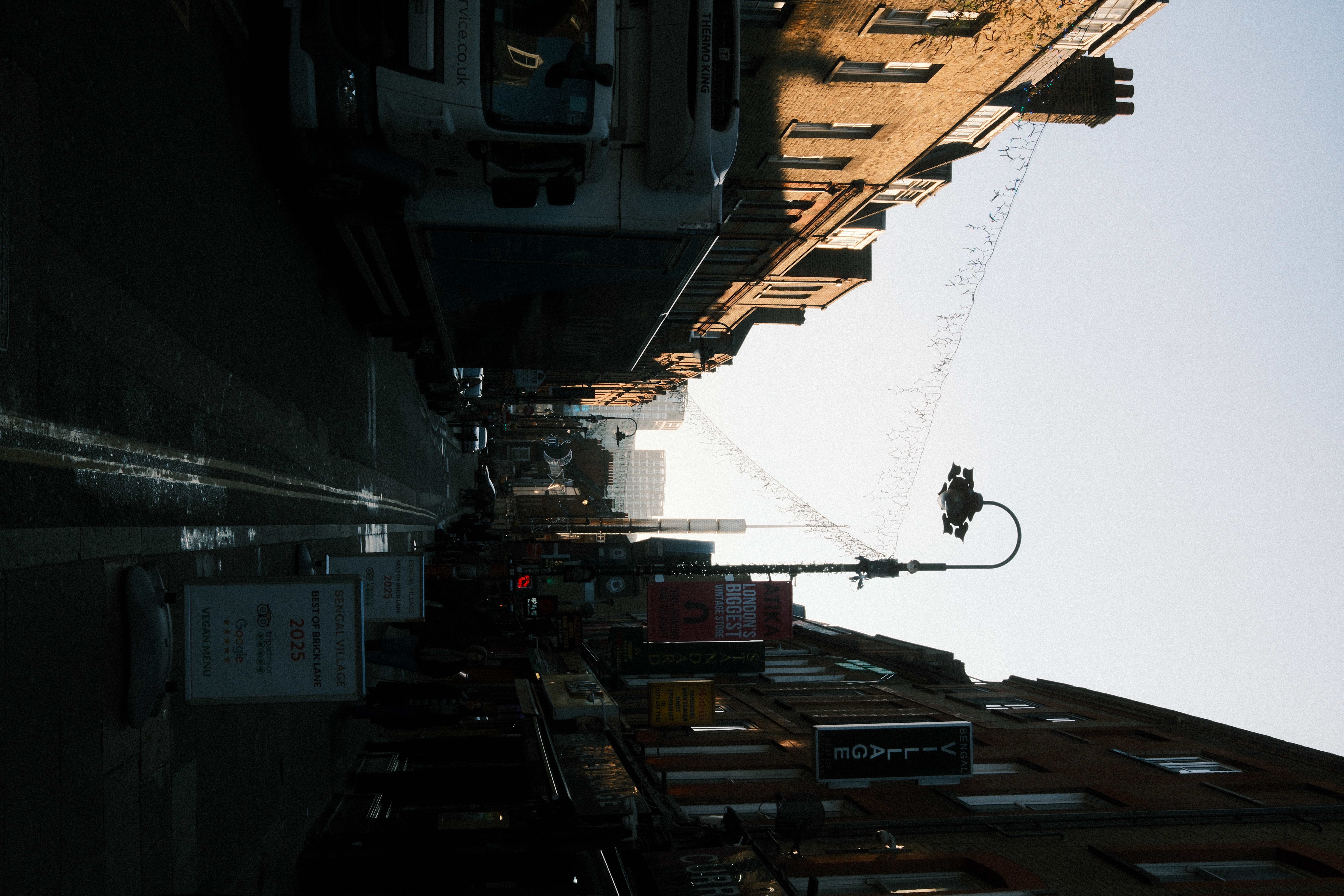 A busy London street with the Shard visible in the background against a pale winter sky