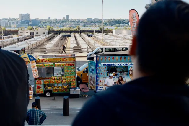 Food trucks and a pink chair overlooking the West Side Yard train tracks from the High Line